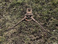 Full view of iron cutter laid flat on grass showing entire structure and handles