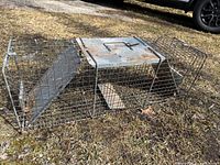 Full view of wire mesh live animal trap lying flat