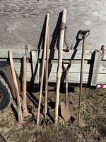 Group shot of six primitive tools leaning against trailer