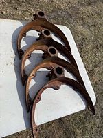 Top view of four matching cast iron brackets laid flat