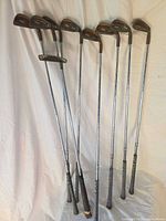 Full view of 10 PING BeCu clubs standing, showing shafts and grips