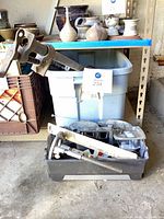 Overall lot showing blue tote with tools and black crate beneath