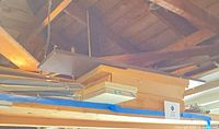 Overview of metal shelf brackets stacked with various wooden boards and a wooden box suspended near ceiling