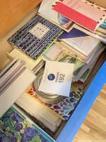 Drawer filled with stacked greeting card boxes and loose cards with envelopes
