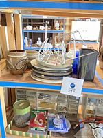 shelving showing Shapiro ceramics, plates, wire stands, glass bottle, organizers and accessories