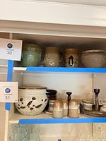 Shelved collection of Robert M Shapiro pottery top and middle shelf