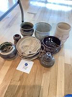 group view of nine pottery pieces on floor