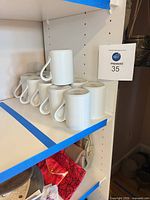 Group of white Dansk Bistro mugs stacked on shelf