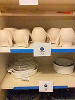 Shelf with eight unglazed bisque coffee mugs