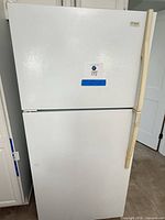 Front view of white Maytag top-freezer refrigerator showing two-door configuration and brand badge