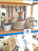 Group of Robert M Shapiro pottery on shelf: shallow bowls, vase, jar, planters