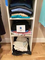 Shelving unit with folded sweaters and t-shirts showing colours and textures