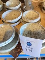 Stacks of speckled ceramic bowls showing glaze, perforations, and stacking