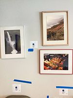 Three framed photographs on wall showing lot contents