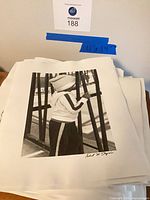 Stack of prints topped by child at fence image, 11x14 size note visible