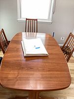 Overall view of wooden dining table with three chairs