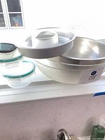 Nested mixing bowls with tube cake pan on top, glass storage containers below
