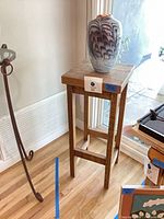 Vase on pedestal table showing overall lot