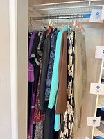 Clothing assortment hanging on closet rod showing variety of colours and types