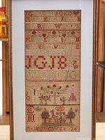 Full view of sampler within frame showing entire design and mat