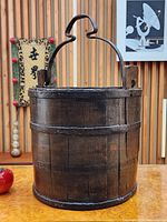 Front view of antique staved wood bucket with wrought iron handle