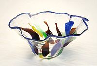 Top view of ruffled glass bowl showing multicolour ribbons and blue rim