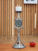 Full view of wrought iron candlestick holder standing 22 inches tall on wood surface