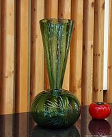 Full view of vase on table showing green color, trumpet neck and bubble pattern