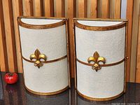 Front view of both sconces showing fiberglass shades, gold trim and fleur-de-lys