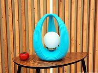 front view of turquoise ribbed ceramic lamp with white globe diffuser