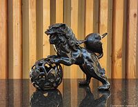 Full left side view of cast iron foo dog with ball