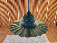 Front angled view showing green radial-wave steel shade and ribbed cap