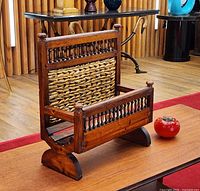 Three-quarter view showing overall form, wood finish, rattan panel, sled feet