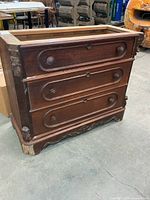 Front view showing three drawers and missing top frame