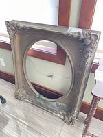 Full view of carved wood frame showing size, oval opening and overall condition