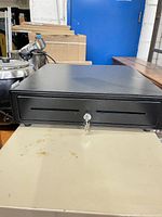 front view of black steel cash drawer showing lock and media slots