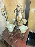 Full view of metal ceiling light with five glass shades