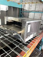 Three-quarter front view of toaster on rack, shows size and overall condition