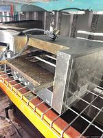 Front and side view of stainless steel conveyor toaster showing control panel and missing conveyor belt
