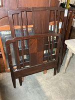 pair of dark wood crib ends leaning together