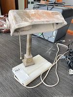 Full view of brass desk lamp on stone base with pull chain visible