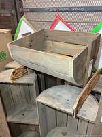 Angled view of wooden display bin resting on other crates