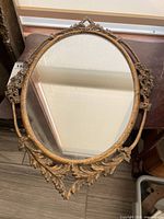 Front view of oval metal framed mirror showing full frame and glass