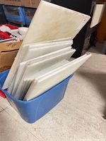 Blue tote holding assorted white polyethylene cutting boards