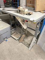 Full view of Juki machine on metal table with pedal