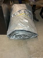 Rolled silver tarp beside furniture