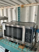 Front and side view of RCA stainless microwave on shelf