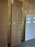 Front view of the three boxed melamine sheets leaning against wall