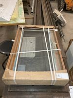 Woodgrain vinyl window in original packaging with straps and cardboard corners