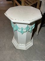 Full view of white painted octagonal pedestal with turquoise appliqués